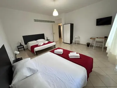 a hotel room with two beds and a table at Peppe's Bed in Rome
