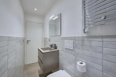 a white bathroom with a sink and a mirror at Domus Capitolina Navona in Rome