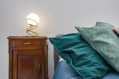 a lamp on a night stand next to a pillow at Apartment Metro San Paolo -Air Conditioning-WIFI-TV55