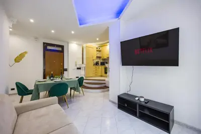 a living room with a couch and a tv on a wall at Apartment Metro San Paolo -Air Conditioning-WIFI-TV55