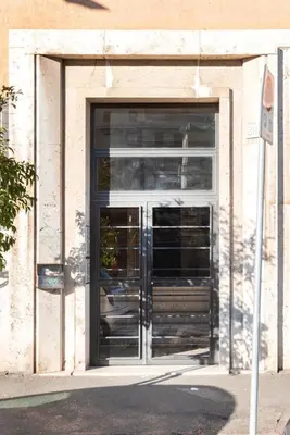 a door to a building with a sign in front of it at Long Bridge Apartment in Rome