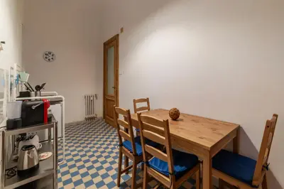 a kitchen with a wooden table and chairs in a room at GuestHost - Piazza Nievo a Trastevere Cozy Apartment in Rome