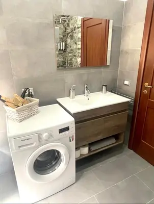a bathroom with a washing machine and a sink at Roman Location San Pietro in Rome