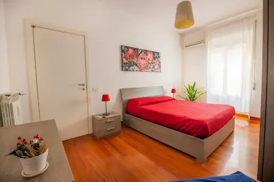 a bedroom with a bed with a red bedspread at Clodia Vatican House in Rome