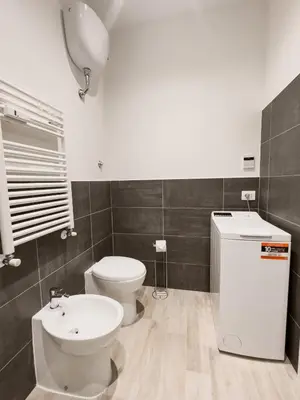 a bathroom with a white toilet and a sink at Flora's Apartment in Rome