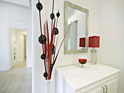 a white room with a vase with flowers in it at Velvet Trastevere Apartment in Rome