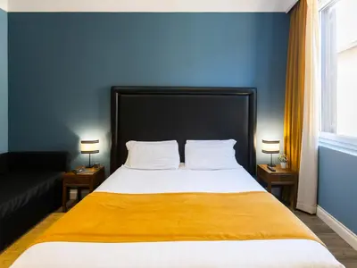 a bedroom with a large bed with a yellow blanket at JB Relais- Campo de' Fiori in Rome