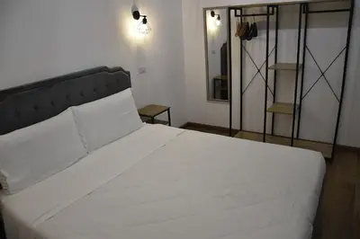 a bedroom with a white bed with a black headboard at Roma Chic Cattolica Gemelli in Rome