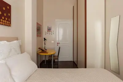 a bedroom with a bed and a table and a door at Casa Farina - Pretty Homes in Rome