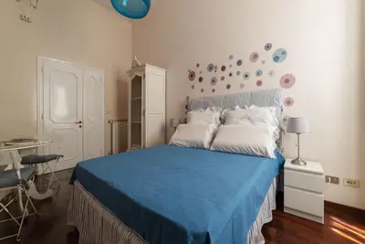 a bedroom with a blue bed with white pillows at Casa Farina - Pretty Homes in Rome