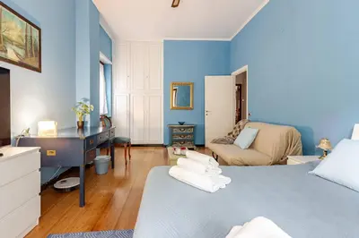 a blue room with a bed and a desk at CASA LORY Balduina in Rome