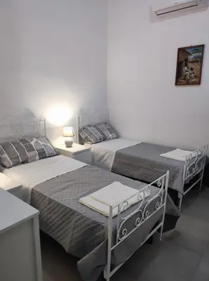 a bedroom with two beds and a table at Appartamento a San Lorenzo Netsuhe in Rome