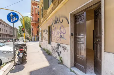 a motorcycle parked on the side of a building with graffiti at FAMM - Cozy flat in Trastevere in Rome