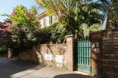 a brick fence with a gate in front of a house at GuestHost - Sant'Agnese & Nomentana Cozy Apartment in Rome