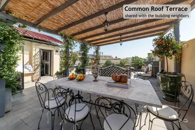 a patio with a table and chairs on a balcony at Toscana 5 - FromHometoRome in Rome