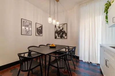a dining room with a black table and chairs at Toscana 5 - FromHometoRome in Rome