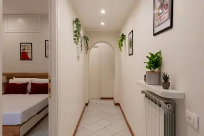 a hallway leading to a bedroom with a bed and plants at Cozy Apartment in Trastevere in Rome