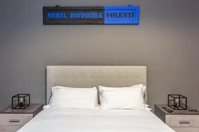 a bed with white pillows and a blue sign above it at The Vatican Dream 3BDR Apartment in Rome