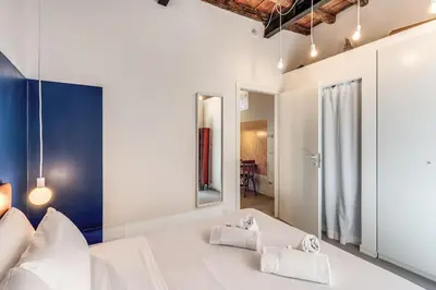 a bedroom with a large white bed with two towels at Trastevere Vicolo del Leopardo suite in Rome