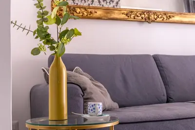 a yellow vase sitting on a table next to a couch at iFlat Cozy and Elegant apt near Spanish Steps in Rome