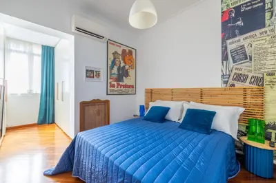 a bedroom with a blue bed with a blue comforter at STRACULT HOUSE Suggestive and Vintage-pop Apartment in Rome