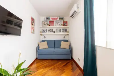 a living room with a blue couch in a room at STRACULT HOUSE Suggestive and Vintage-pop Apartment in Rome