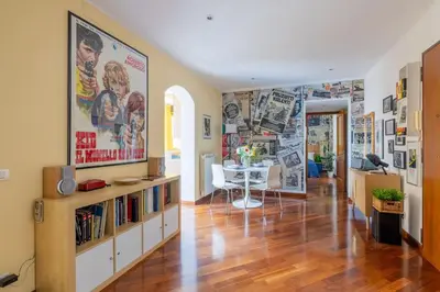a living room with a table and posters on the walls at STRACULT HOUSE Suggestive and Vintage-pop Apartment in Rome