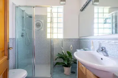 a bathroom with a glass shower and a sink at STRACULT HOUSE Suggestive and Vintage-pop Apartment in Rome