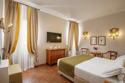 a bedroom with a bed and a tv and curtains at Hotel Mozart in Rome