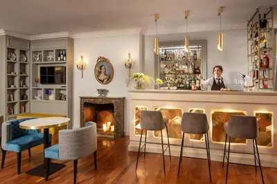 a man standing behind a bar in a room with a fireplace at Hotel Mozart in Rome