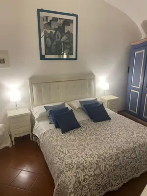 a bedroom with a large bed with blue pillows at La casa di vasco in Rome
