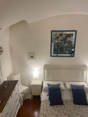 a bedroom with a bed and a dresser with a picture on the wall at La casa di vasco in Rome
