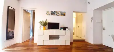 a living room with a tv on a white cabinet at Cheerful flat in funky Rome in Rome