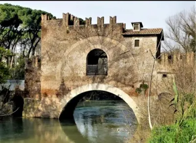 an old bridge over a river with a castle at Casa Flora in Rome