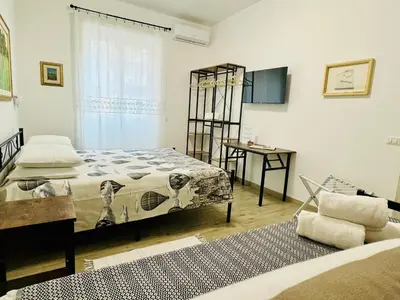 a bedroom with a bed and a desk and a window at Casa Flora in Rome