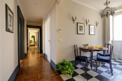 a dining room with a table and chairs and a hallway at Daplace - Lavinia Apartment in Rome