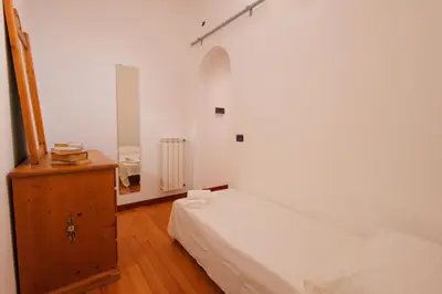 a bedroom with a white bed and a wooden cabinet at Villa Aureliana with pool near San Peter in Rome