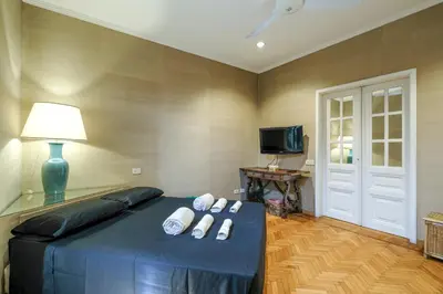 a bedroom with a bed with a lamp and a television at PIRAMIDE SHABBY by Casa e Lode - colosseum, air conditioning in Rome