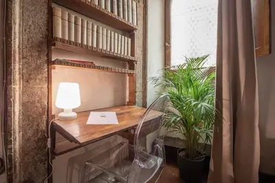 a desk with a lamp and plants in a room at Suite Benedetta - Trastevere Luxury in Rome