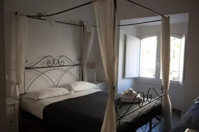 a bedroom with a black canopy bed with a window at Vatican Leone IV in Rome