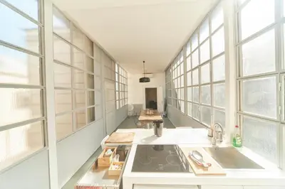a kitchen with white counters and windows and a sink at Roma Stazione Termini 300 mq appartamento con 4 camere vista e idromassaggio in Rome