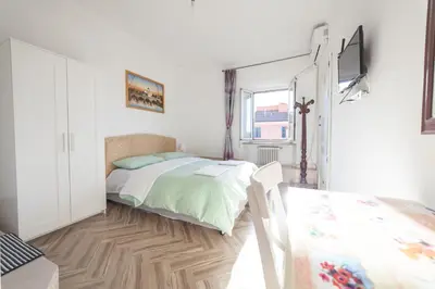a white bedroom with a bed and a window at Meile House in Rome