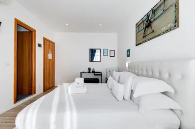 a white bedroom with a large white bed with white pillows at Ripetta Central Suites in Rome