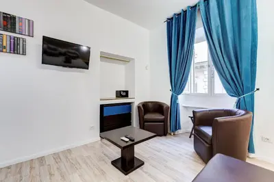 a living room with two chairs and a tv at Ripetta Central Suites in Rome
