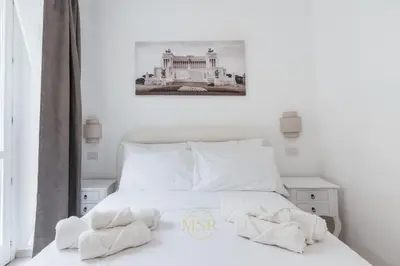 a bedroom with a white bed with towels on it at MysuiteRome in Rome