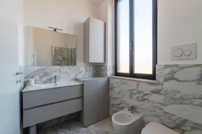 a white bathroom with a sink and a mirror at GuestHost - MM San Giovanni Apartment in Rome