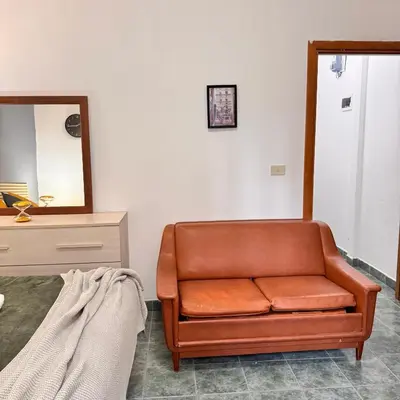 a brown leather chair in a room with a mirror at Bella Roma Stay in Rome