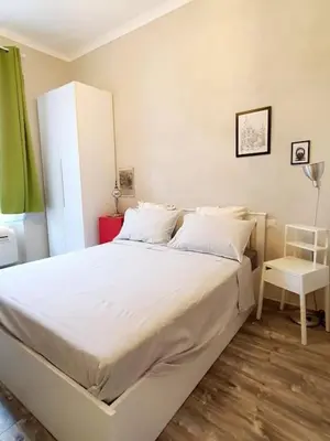 a bedroom with a large white bed and a chair at Charming house in Rome