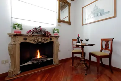 a living room with a fireplace and a table with wine glasses at Terrazze Navona in Rome
