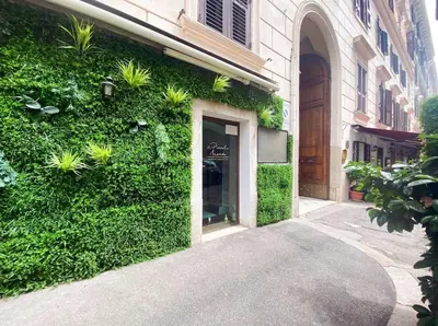 a building with a green wall with plants on it at Via Veneto - Domus Juliae in Rome